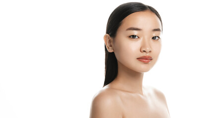 Asian beauty. Young beautiful woman with clear, glowing and hydrated facial skin, standing with bare shoulders, after shower glow, looking at camera, white background