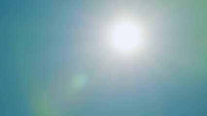 beautiful sparkle sun moves across clear blue sky. sun rays light isolated on blue background. real 