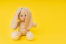 Toy Bunny Sitting On A Bright Yellow Background