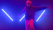 © stockbusters - Guy dancing street style in neon backlit. Stylish b-boy enjoying freestyle.