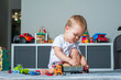 Toddler boy plays in playroom with educational toys...