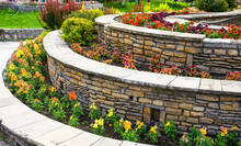 Landscaping With Retaining Walls And Flowerbeds In Residential House Backyard