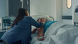 © stockbusters - Wife sitting sick patient at hospital ward. Loving partner supporting husband.