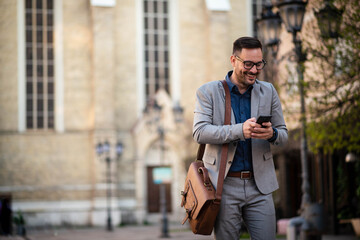 Wall Mural - Business man walking and texting on phone