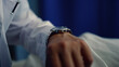 © stockbusters - Doctor hand with watch on wrist closeup. Therapist check time in hospital ward.