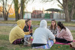 © Gino Gallucci - Group of friends chatting in the park