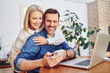 © baranq - Happy middle aged couple doing online payment with mobile phone