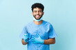 © luismolinero - Moroccan dentist man holding tools isolated on blue background smiling a lot