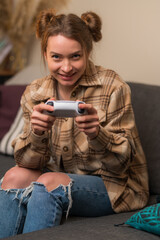 Wall Mural - Close-up. A girl with a joystick in her hands plays video games online with friends. Teenagers play a video game, competition, excitement. Prizes, win, surprises. Youth culture.