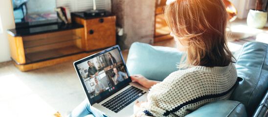 Woman browsing network on laptop and siting on couch