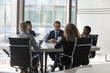 © fizkes - Diverse millennial business group brainstorming, at conference table. Startup leaders, project investors meeting, analyzing marketing reports, negotiating on investment, deal