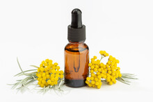 Helichrysum Essential Oil On Amber Bottle Isolated On White Background. Herbal Oil