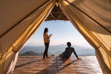 Young couple traveler looking beautiful landscape at sunset and camping on mountain, Adventure travel lifestyle concept