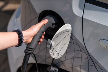 Sticker - Woman holding plug of electric car charging station