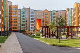 Fototapeta Łazienka - Bright urban landscape of a new residential area with modern multi-apartment colored houses and a well-maintained house territory