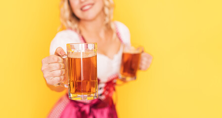 Wall Mural - Woman in festive German dress holds out mug of beer forward.