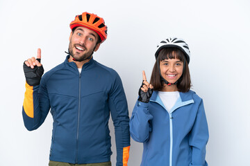 Canvas Print - Young cyclist couple isolated on white background showing and lifting a finger in sign of the best