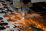 Fototapeta  - Automatic cnc laser cutting machine working with sheet metal with many orange sparks at factory, plant. Metalworking, industrial, manufacturing, technology and equipment concept