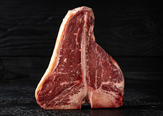 Wall Mural - Raw T Bone beef steak with herb and seasoning on rustic background