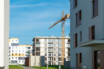 Wall Mural - Construction crane among modern residential buildings on a sunny day