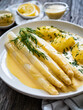 Leinwandbild Motiv White boiled asparagus in hollandaise sauce with potato puree served on wooden black table
