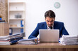 © Elnur - Young male employee and too much work in the office