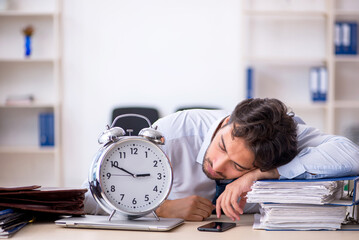 Wall Mural - Young male employee in oversleeping concept