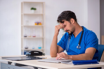 Wall Mural - Young male doctor working in the clinic