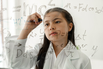cute little girl student child learning research and doing a chemical experiment and write scientifi