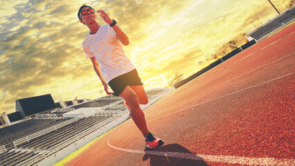 Sticker - Fit young man running sprinting at the racetrack. Fit runner fitness runner during outdoor workout at racetrack. Start running concept.