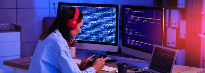 Young female programmer working in office at night