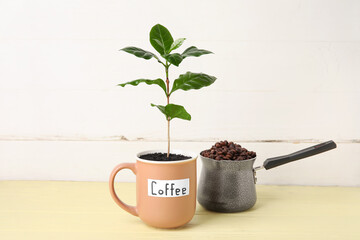 Wall Mural - Cup with coffee tree and pot of beans on table