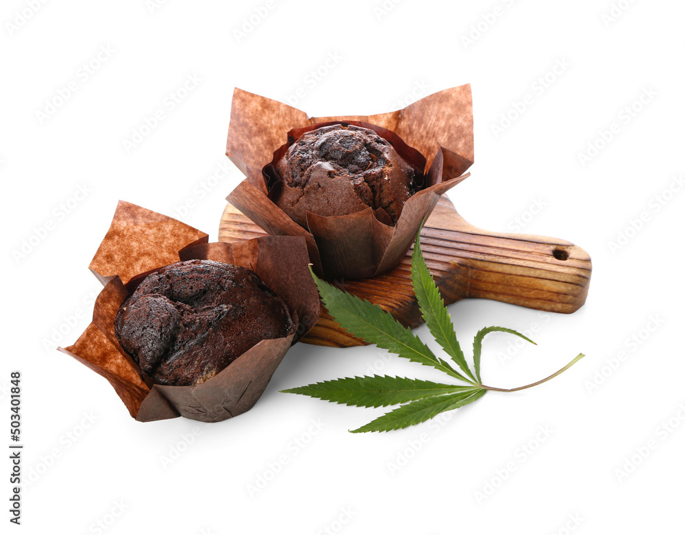 Wooden board with chocolate cannabis muffins on white background