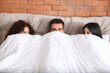 © Pixel-Shot - Man with two beautiful women in bed. Polyamory concept