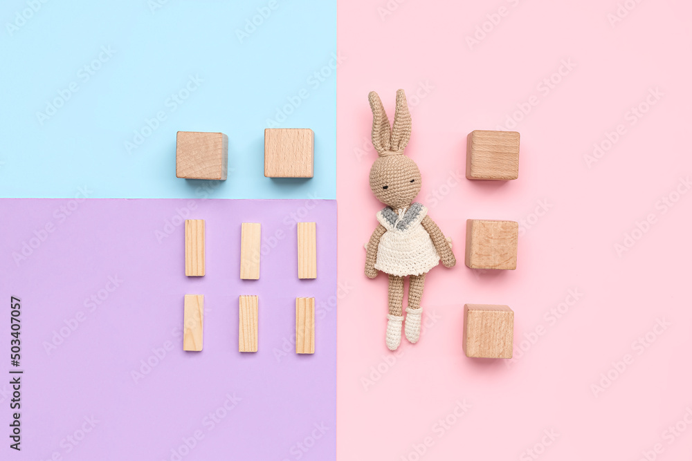 Wooden cubes with blocks and toy on color background