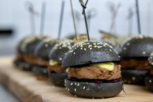 Mini Burger Sliders On A Wooden Board Up Close Low Light With Grain And Out Of Focus