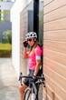 © Westend61 - Cyclist wearing sunglasses standing by bicycle in front of building