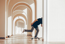 Man With Skateboard Practicing In Arcade