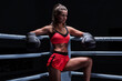 © andy_gin - Athletic woman in red shorts and top posing in the ring. Boxing and mixed martial arts concept.