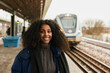 © Johnér - Smiling woman standing at train station