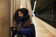 © Johnér - Woman using phone at train station