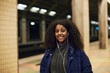 © Johnér - Smiling woman standing at train station