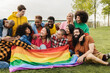 © Vane Nunes - Happy diverse friends holding LGBT rainbow flag having fun together outdoors - Focus on right man with leg prosthesis
