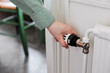 © Johnér - Hand adjusting temperature control in radiator