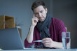 © VK Studio - Unhealthy looking male freelancer feeling unwell and cold, wearing warm knitted scarf around neck