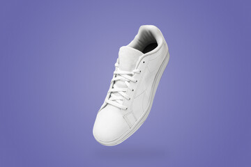 High angle view of white sneaker isolated on purple (very peri) background. Sportive pair of shoes for mockup. Fashionable stylish sports casual shoes.