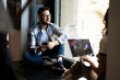 © JustLife - Young man sitting and listening the music. Portrait of happy bearded man listening music with earphones while singing song.