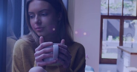 Poster - Animation of light spots over caucasian woman drinking coffee at home