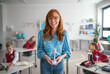 © Halfpoint - Elementary school teacher holding wind turbine and learning kids about eco-friendly forms of renewable energy