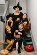 © zzzdim - Mother and four girls posing for haloween photo, sitting on the stairs.